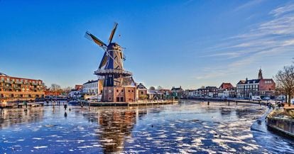 Estampa invernal del río Spaarne, con el molino De Adriaan, en Haarlem (Países Bajos).