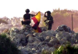 Soldados españoles arrían la bandera en la isla de Perejil poco antes de terminar la evacuación.