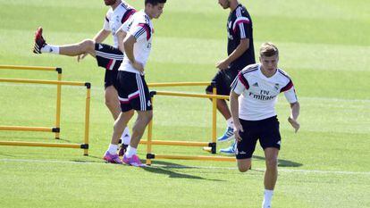 Kroos esprinta ante James y Xabi Alonso en un entrenamiento del Madrid.