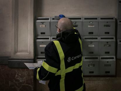 Un cartero distribuye el correo en un edificio de Barcelona.