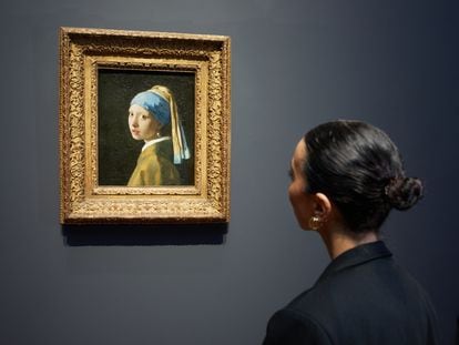 Una mujer observa el cuadro 'La joven de la perla', de Johannes Vermeer.