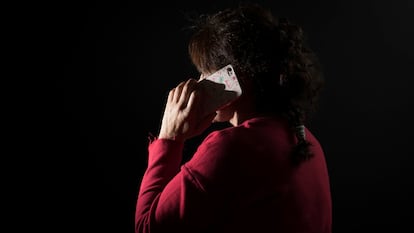 Una mujer víctima de maltrato habla por su teléfono móvil.