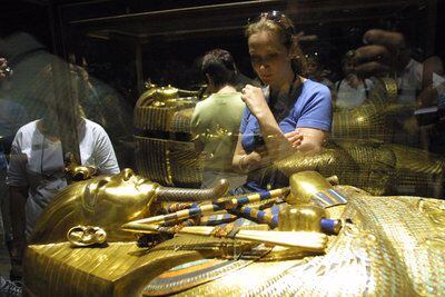 Varios visitantes observan el sarcófago de oro del faraón Tutankamón, en el Museo Egipcio de El Cairo