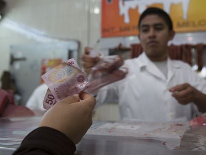 Un cliente paga sus compras en el mercado de Medellín, en Ciudad de México.