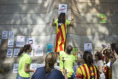 Una joven pega carteles a favor de la celebración del referéndum del próximo 1 de octubre.