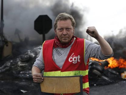 Un sindicalista mira a c&aacute;mara tras crear una barricada para impedir el acceso a una refiner&iacute;a durante la huelga en Douchy les Mines, al norte de Francia.