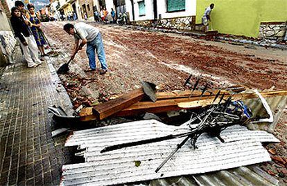 Vecinos  de Centelles limpian el barro y los cascotes de la calle tras la turbonada que ayer afectó el sur de Osona.