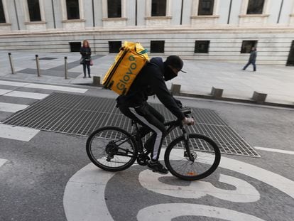 Un ciclista repartidor de Glovo por la Carrera de San Jerónimo de Madrid.