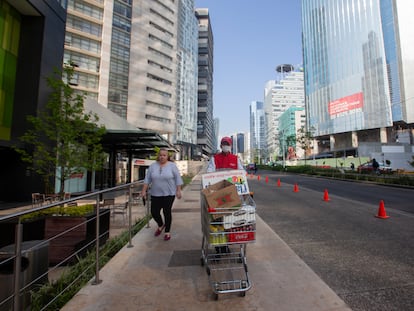 Un empleado de supermercado lleva la compra de un cliente en la zona de Santa Fe.