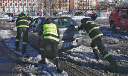 Militares de la UME ayudan a un coche a salir de la nieve en la Estación Puerta de Atocha, en Madrid (España), a 11 de enero de 2020. 