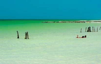 Dos turistas se relajan en las aguas poco profundas de la isla de Holbox (México).