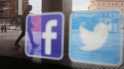 Los logos de las redes sociales Facebook y Twitter aparecen en el escaparate de una tienda en Málaga.