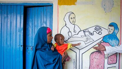 Una madre desplazada recientemente por la sequía sostiene a su bebé desnutrido en un centro de estabilización de la desnutrición administrado por Acción contra el Hambre, en Mogadiscio, Somalia.