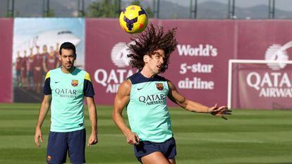 Busquets observa a Puyol en el entrenamiento del Barcelona. 