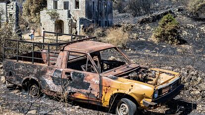 Turistas pasean por los restos del incendio en Palia Pericia.