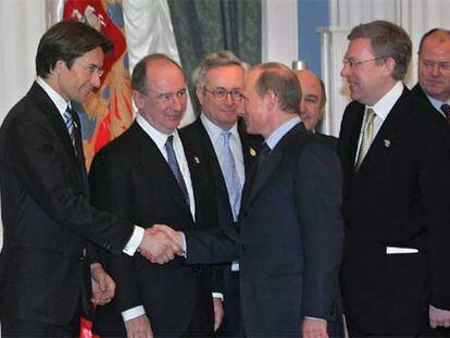Vladímir Putin (derecha) estrecha la mano del ministro de Finanzas austriaco, en presencia de Rato (entre ellos).
