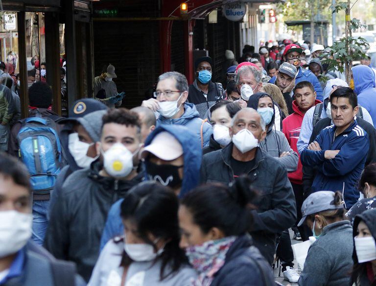 Una cola de desempleados con mascarillas esperan para solicitar el seguro de desempleo en Santiago de Chile.