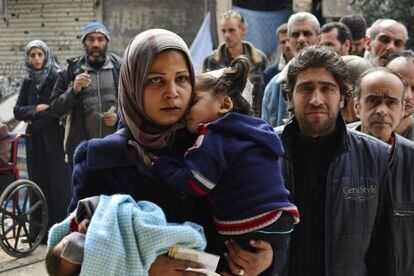 Refugiados del campo de Yarmuk guardan cola para recibir comida en marzo.