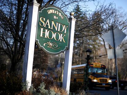 A bus drives past a sign reading Welcome to Sandy Hook in Newtown, Conn., Dec. 4, 2013.