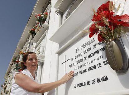Manuela Lago cuida la lápida de la tumba en la que, desde 1993, descansan los restos de 22 de los asesinados en Casas Viejas (Cádiz), entre ellos su abuelo y su tía.