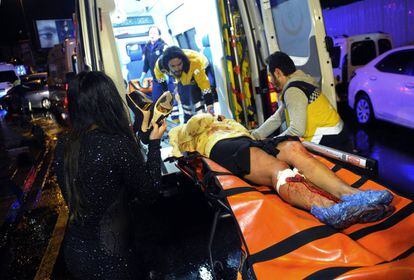 Personal sanitari trasllada en una ambulància a una víctima de l'atac en la discoteca Reina.