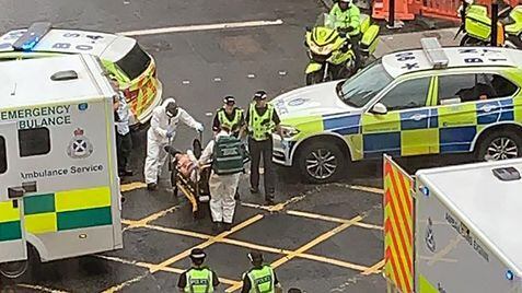 Los servicios de emergencia trasladan a uno de los heridos, este viernes, en Glasgow. En vídeo, fuerte presencia policial en la zona del ataque.