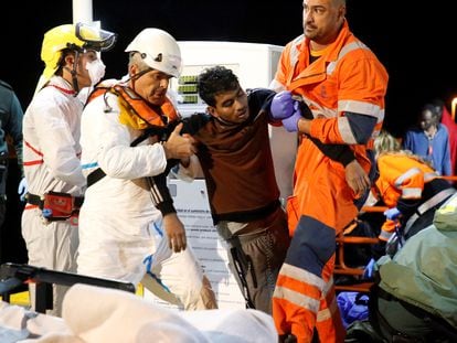 Un joven es ayudado por miembros de Salvamento Marítimo a su llegada al puerto de Melilla, en noviembre de 2019.