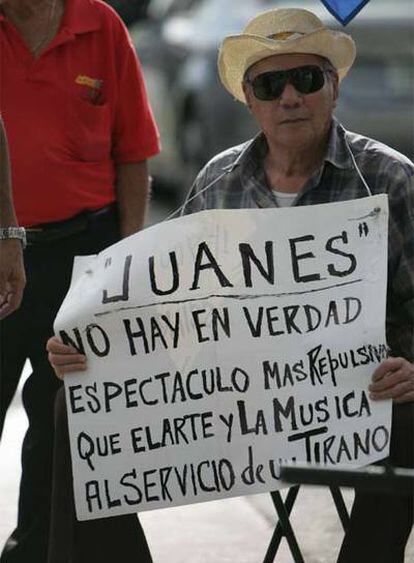 Un hombre sostiene un cartel contra el concierto de Juanes en La Habana