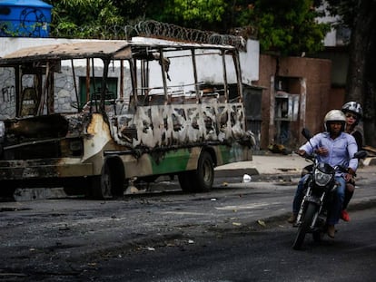 Un autob&uacute;s incendiado durante los disturbios de este domingo.