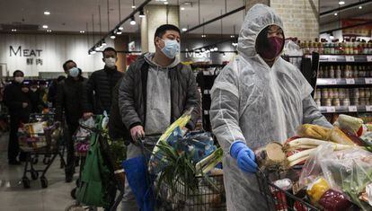 Varios ciudadanos de Wuhan, con mascarillas y protección para evitar el contagio del coronavirus.