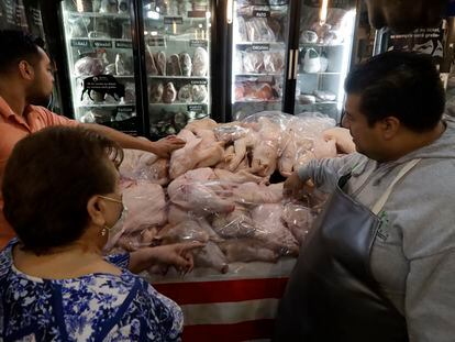 Una mujer compra ingredientes para su cena de Navidad, en el mercado de San Juan en Ciudad de México.