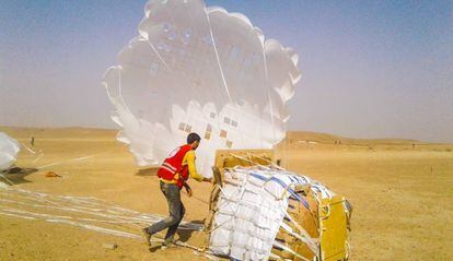 La Media Luna Roja Árabe Siria recibe en tierra alimentos y otros suministros humanitarios lanzados por el PMA desde gran altura sobre Deir Ezzor, en Siria.