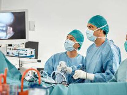 Cirujanos observan un monitor durante una intervención de rodilla. Getty