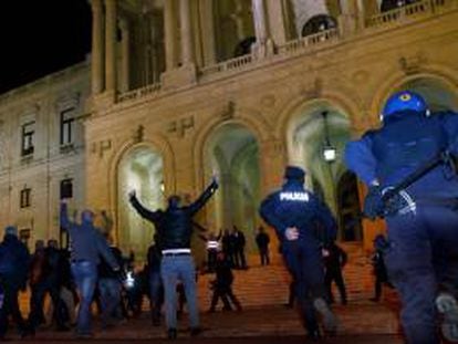 Las fuerzas anti disturbios intentan detener a manifestantes que gritan arengas y llevan pancartas hoy, jueves 21 de noviembre de 2013, durante una protesta de la policía y las fuerzas de seguridad portuguesas frente al Parlamento en Lisboa (Portugal). La protesta es contra los recortes en los salarios de estos organismos que fueron decididos por el Gobierno demócrata en el presupuesto de 2014.