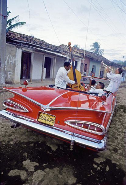Músicos en un viejo Chevrolet Impala de 1959 por una calle de Trinidad, en Cuba.