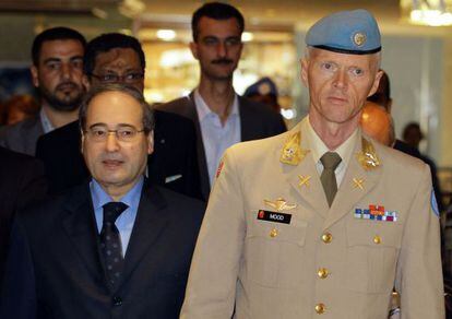 El viceministro de Exteriores sirio, Faisal al Miqdad (Izq.) camina junto al jefe de la misi&oacute;n de observadores de la ONU, el general Robert Mood, hoy en Damasco, despu&eacute;s de celebrar una reuni&oacute;n.
