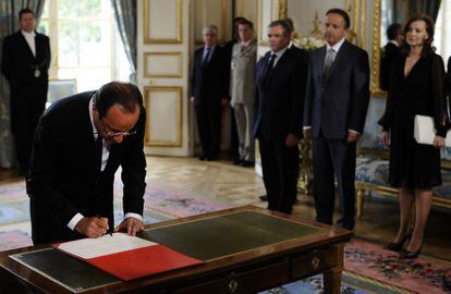 Hollande firma tras recibir la condecoración de Gran Maestre de la Legión de Honor ante su compañera Valerie Trierweiler y los presidentes de la Asamblea Nacional y el Senado.