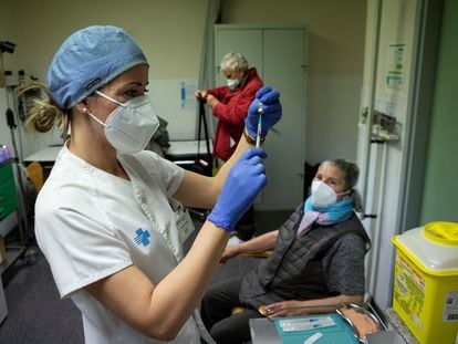 Una enfermera se dispone a inyectar la primera dosis de la vacuna contra la covid a una anciana en Barcelona, el 3 de marzo.