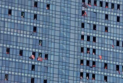 Aficionados del equipo rojiblanco animan al equipo desde las ventanas de un edificio de apartamentos.