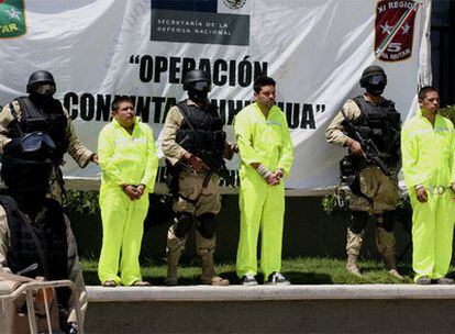 Tres de los cuatro detenidos en Ciudad Juárez son mostrados a la prensa custodiados por la policía.