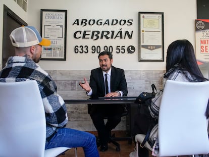 Alberto García Cebrián habla con unos clientes que han ido al despacho a informarse después de una separación en Leganés, Madrid.