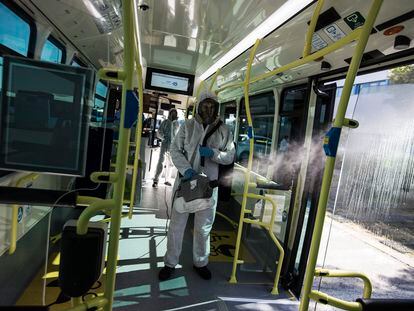 Un operario de la EMT desinfecta con un nebulizador un autobús de línea de la Empresa Municipal de Transportes de Madrid.