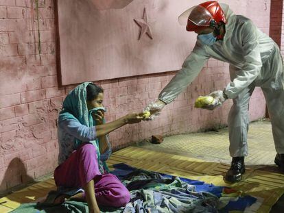 Una mujer sin hogar recibe alimentos de un grupo de voluntarios durante el confinamiento por la covid-19 en Bangladés en 2020.
