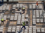 Sevilla/28-07-2021: Daniel Cordero (chaleco naranja), gruista en la construcción, junto a una sombrilla y un dispensador de garrafas de agua ubicadas en la zona de trabajo.FOTO: PACO PUENTES/EL PAIS