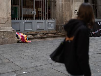 Una alumna observa la fachada de la Parroquia Immaculada Concepcio i Sant Llorenç donde han encontrado distintos elementos hostiles, aun así, hay gente durmiendo junto a la fachada.