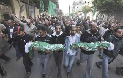 Hombres palestinos sostienen los cadáveres de dos niños, durante su funeral en Gaza.