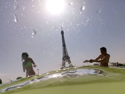 Dos personas se bañaban este jueves en una fuente cercana a la Torre Eiffel, en París.