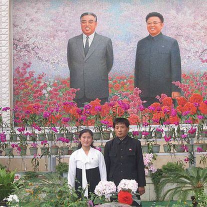 Una pareja se fotografía ante el retrato de Kim Il Sung (izquierda) y Kim Jong Il.