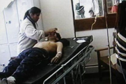 Imágenes tomadas de la TV de uno de los mineros heridos de Huanuni, en el hospital de esta localidad, donde es atendido por una enfermera.