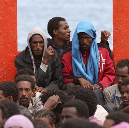 Un grupo de inmigrantes a bordo de un barco de la Armada italiana frente a Augusta en junio.